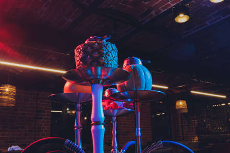 Red shisha hookah with smoke and red sparks on wood table brick, art background. Shisha Concept.の写真素材