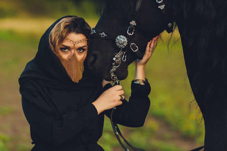 Muslim woman in hijab riding a horse.の写真素材
