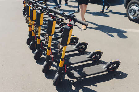 Electric scooters in row on the parking lot. City bike rental system, public kick scooters on the...