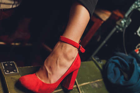 close - up of a young womans feet in red high-heeled genuine leather shoes.