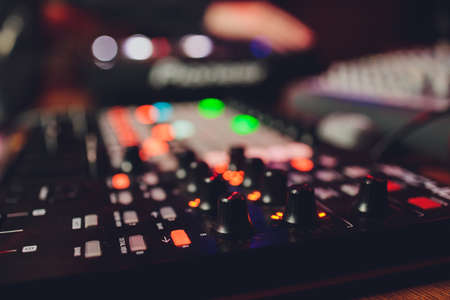 The DJs hand on the mixer. Dj on the turntables. hand on a mixer close-up. Girl Man DJ at the mixer remote.の写真素材