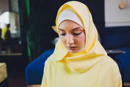 Muslim woman in hijab praying on mat indoors.の写真素材