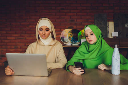 Young muslim asian female designer using graphics tablet while working with computer at studio or office.の写真素材