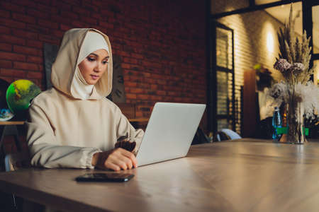 Young muslim asian female designer using graphics tablet while working with computer at studio or office.の写真素材