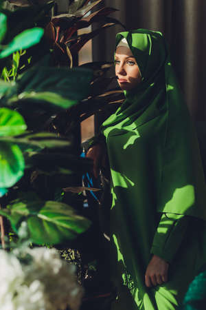 Portrait of a beautiful, elegant and attractive young Malay Asian Muslim woman in a dress and an hijab head scarf.の写真素材