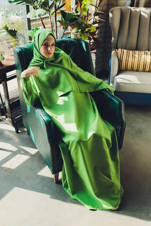 Portrait of a beautiful, elegant and attractive young Malay Asian Muslim woman in a dress and an hijab head scarf.の写真素材