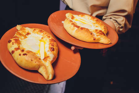 Homemade Ajarian Khachapuri with Sulguni Cheese Filled with a Raw Egg and Melted Butter Close Up....