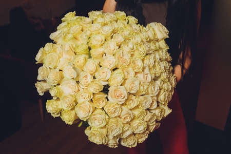 attractive young girl holding a large basket with white roses close up.の写真素材
