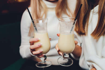 Happy woman at a party smiling and holding a cocktail drink.の写真素材