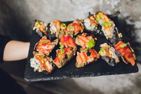 Canape, appetizers, on the table, buffet menu, European cuisine, shrimp, mini burger on a wooden...