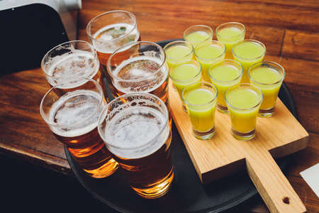 Waiter serving glasses of cold beer on the tray.