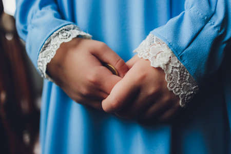 Side portrait of a little Muslim girl wearing a blue hijab. Concept of Muslim clothing for children.