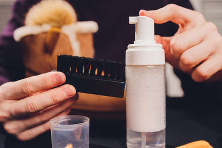 Hands cleaning mens camel suede desert shoe boot with a brush.の写真素材