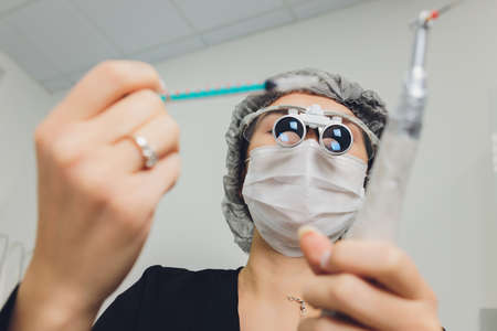 feMale dentist in special glasses with magnifying glasses and mask. Medical worker.