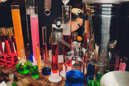 Test tubes with multi-colored liquid. Alcohol in test tubes dark bar.