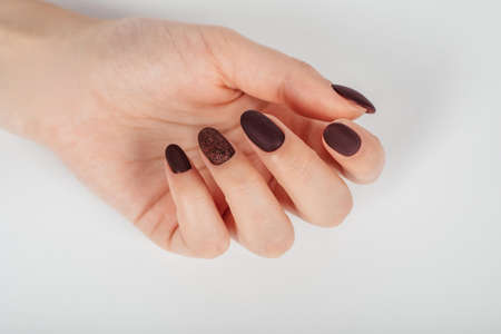 Female hand with brown nail design. Brown glitter nail polish manicure. Woman hand.の写真素材