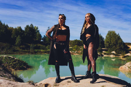 Woman dressed in a steampunk suit against the background of a dirty lake.