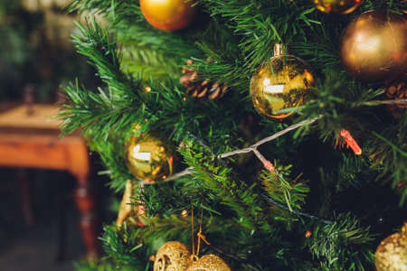 Closeup of christmas fir tree decorated with gold, toys, balls and garland. Traditional winter holidays Christmas New Year.の写真素材