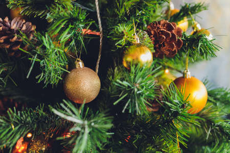 Closeup of christmas fir tree decorated with gold, toys, balls and garland. Traditional winter holidays Christmas New Year.の写真素材