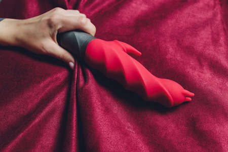 Woman in bedroom holding vibrator in hand.の写真素材