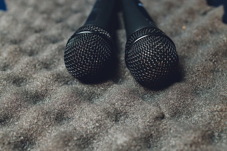 Two silver microphones isolated over white background . Two wireless microphones on the conference table.の写真素材
