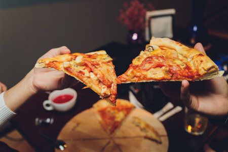 Close up image of a female hands holding a slice of pizza.の写真素材