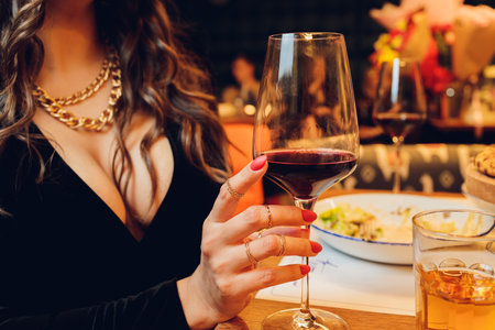 Young girl holding martini glass with red drink in the bar.の写真素材