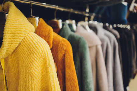 Coats and jackets on hangers in the store. Sale of outerwear.の写真素材