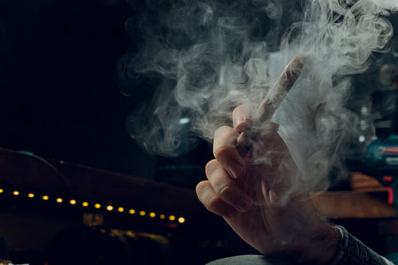 Man smokes new Vape Pod System, inhales and exhales vapor of electronic cigarette, vaping concept.の写真素材