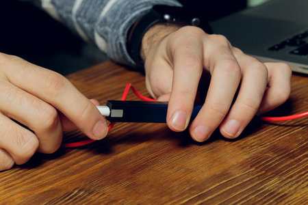 POD e-cigarette or nicotine vapor dispenser being charged in modern laptop with Pods.の写真素材