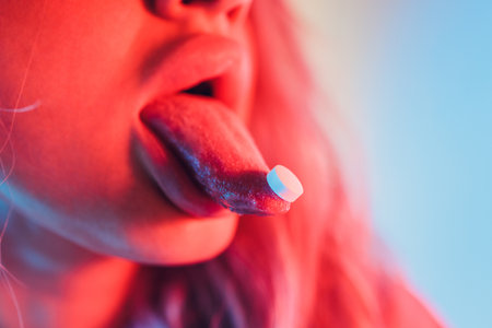 beautiful girl with lsd on tongue in nightclub with pink smoke.の写真素材