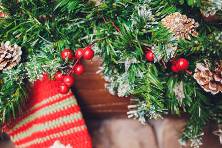 Christmas stockings hanging over a fireplace with candles on the mantlepiece.の写真素材