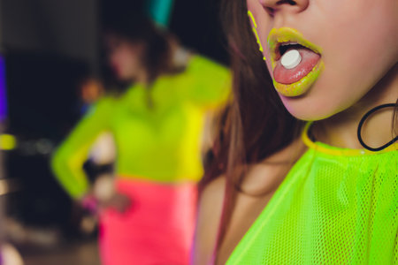beautiful girl with lsd on tongue in nightclub with pink smoke.の写真素材