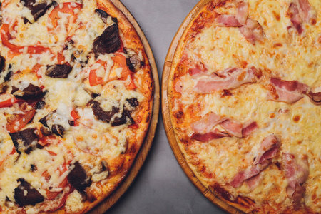 Slices of pizza on rustic wooden tray and dark background.の写真素材