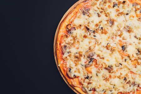 Slices of pizza on rustic wooden tray and dark background.の写真素材