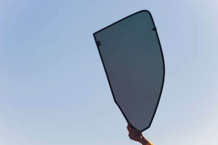 Hand holding folding sunshade retractable for windows or car windshield.の写真素材