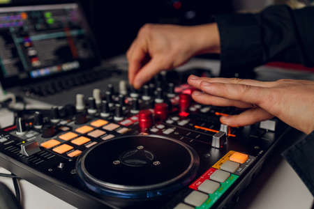DJs hand over the laptop and mixing console controlling the sound settings.