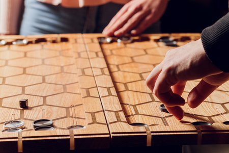 Playing backgammon game. Man play board game. Dice on wooden board.
