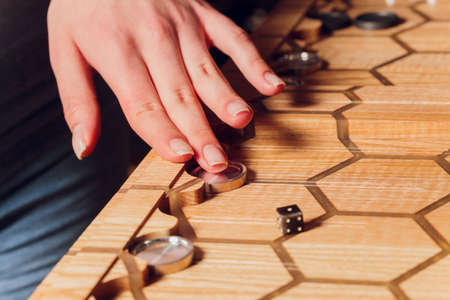 Playing backgammon game. Man play board game. Dice on wooden board.