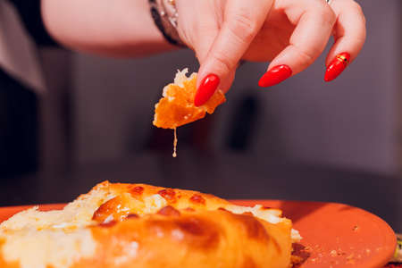 Woman is eating adjarian khachapuri with hands, crushing egg yolk.の写真素材