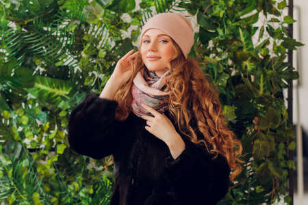 happy beautiful woman looking sideways in excitement. girl wearing knitted warm hat and mittens.