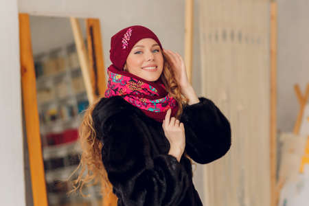 happy beautiful woman looking sideways in excitement. girl wearing knitted warm hat and mittens.