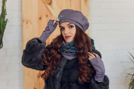 happy beautiful woman looking sideways in excitement. girl wearing knitted warm hat and mittens.の写真素材