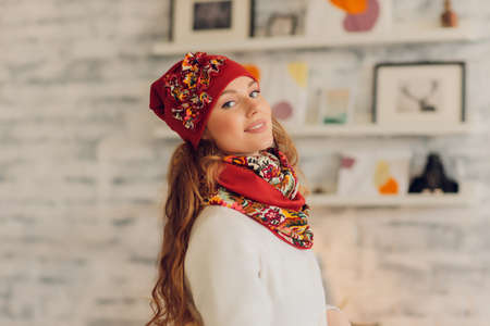 happy beautiful woman looking sideways in excitement. girl wearing knitted warm hat and mittens.の写真素材