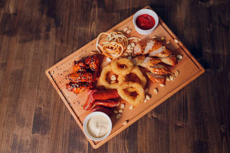 wide selection of snacks for beer with different sauces on parchment top view.の写真素材