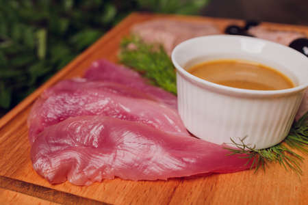 Cold meat on cutting board on wooden table. Ham, salami, sausage mortadella and turkey.の写真素材