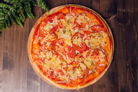 cut into pieces of pizza sausage, salami and cheese on a wooden platter.の写真素材