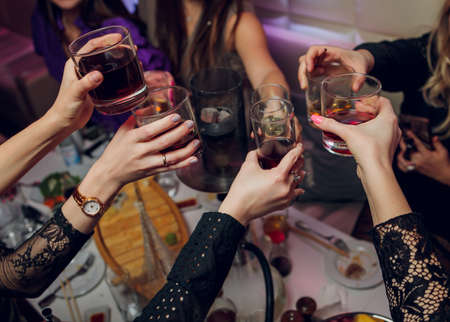 Clinking glasses with alcohol and toasting, party.の写真素材