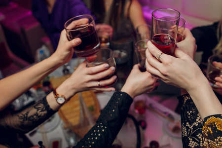 Clinking glasses with alcohol and toasting, party.の写真素材