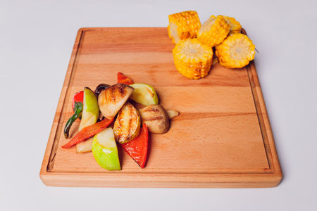 Homemade organic grilled summer vegetables on rustic table. Corn, pepper, onion, eggplant, zucchini. Vegetarian food concept.の写真素材